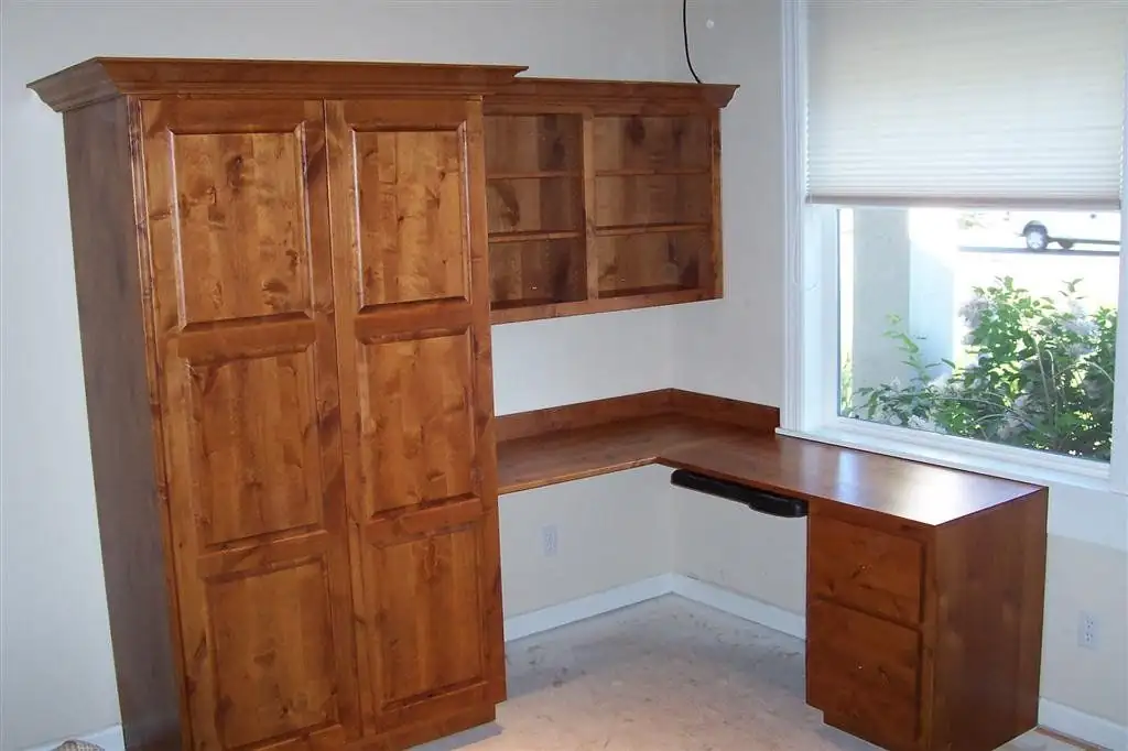 Custom cabinets in Polson, MT from Jackson Woodworks: stained wood tall cabinet, upper shelves and a built-in corner desk with drawers